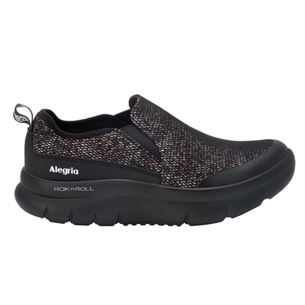 Black double-gore shoe with a dotted design and a pull tab, labeled "ALEGRIA SHIFT LEAD CREATURE COMFORT - WOMENS" on the side.
