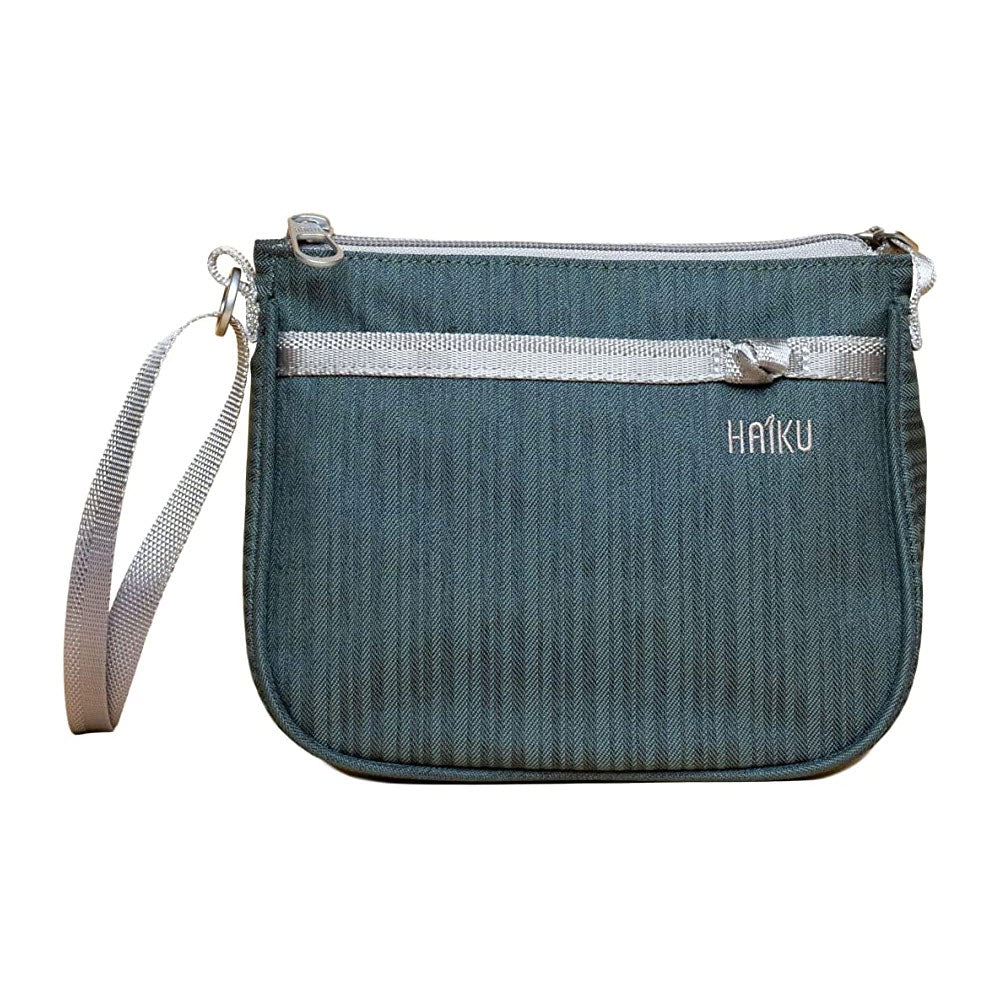 Small teal Haiku Lark Crossbody bag with a silver zipper and a gray strap, featuring an RFID-blocking slip pocket, isolated on a white background.