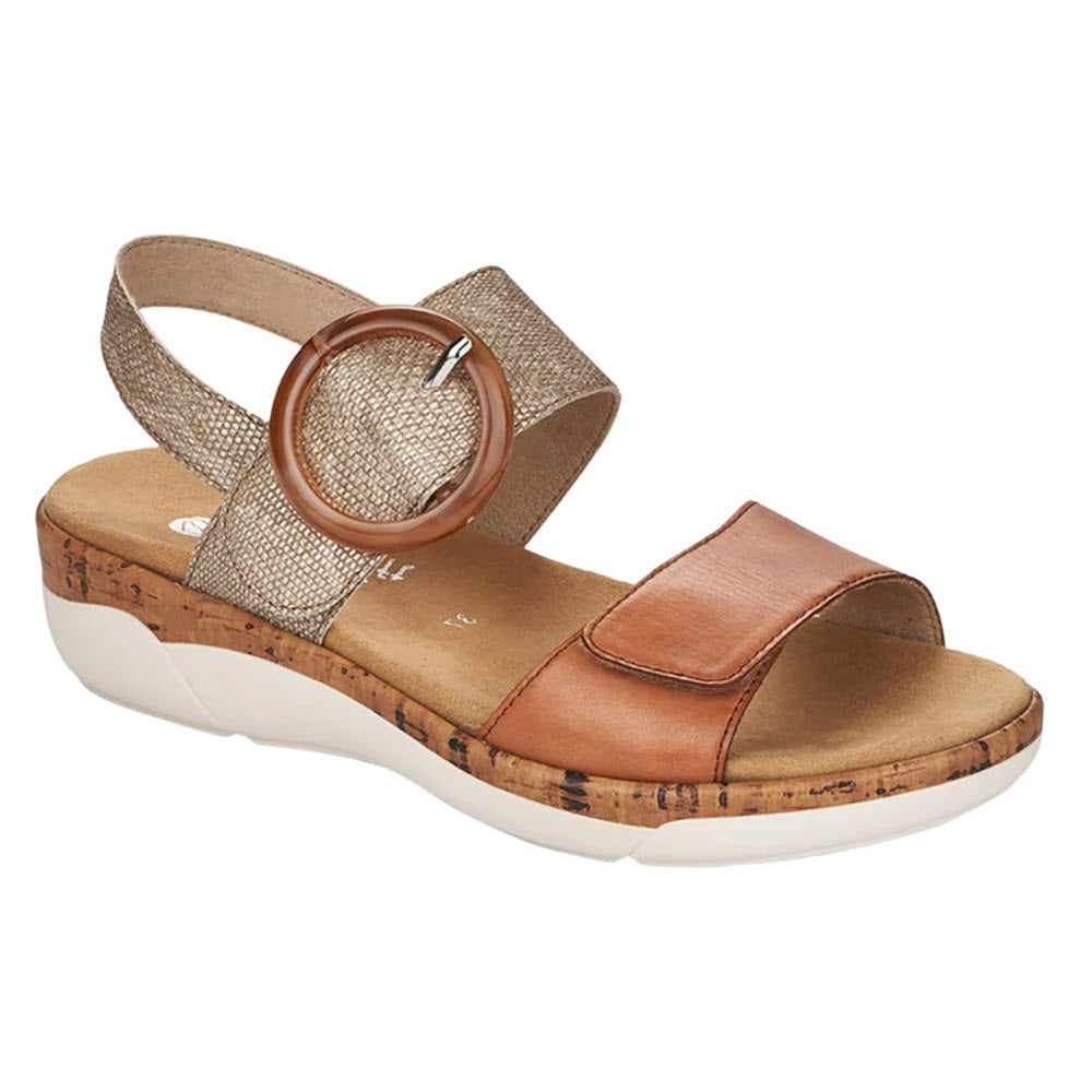 A women&#39;s wedge sandal featuring a cork wedge, two-tone adjustable straps in metallic and tan leather, and a circular buckle is the Remonte Comfort Big Buckle Sandal Tan/Silver.