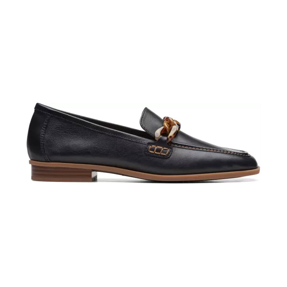Black leather upper Clarks Sarafyna Iris loafer with a gold-tone buckle and twisted ornamentation on a white background.