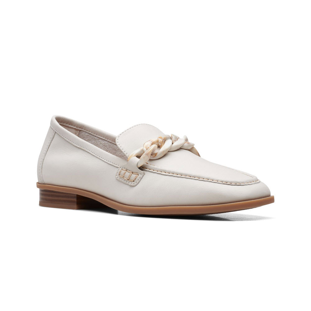 A Clarks Sarafyna Iris White loafer with a tassel on the vamp and a brown wooden heel, isolated on a white background.