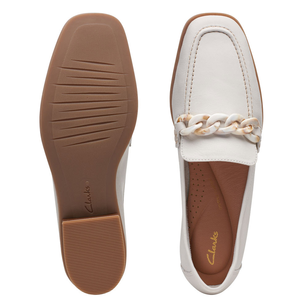 Top and bottom view of a white Clarks Sarafyna Iris loafer with a decorative chain, showcasing the sole and the insole.