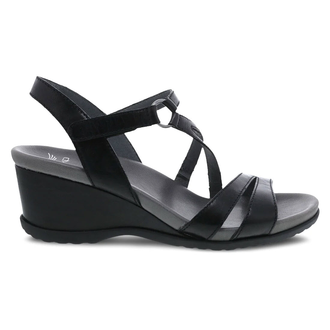 Dansko Addyson glazed black strappy leather wrapped wedge sandal with a hook-and-loop ankle strap and asymmetrical detailing on a white background.