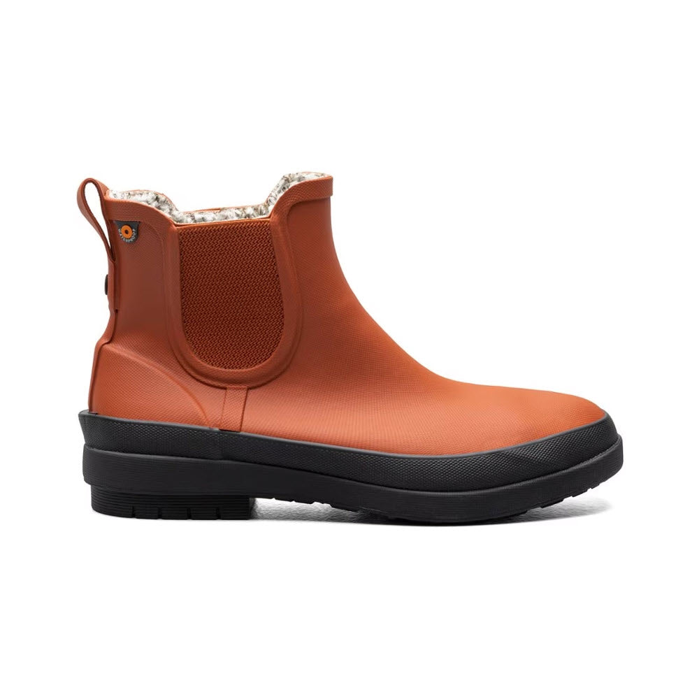 A single BOGS AMANDA PLUSH II CHELSEA BURNT ORANGE - WOMENS boot with elastic side panels and a thick black sole, isolated on a white background.