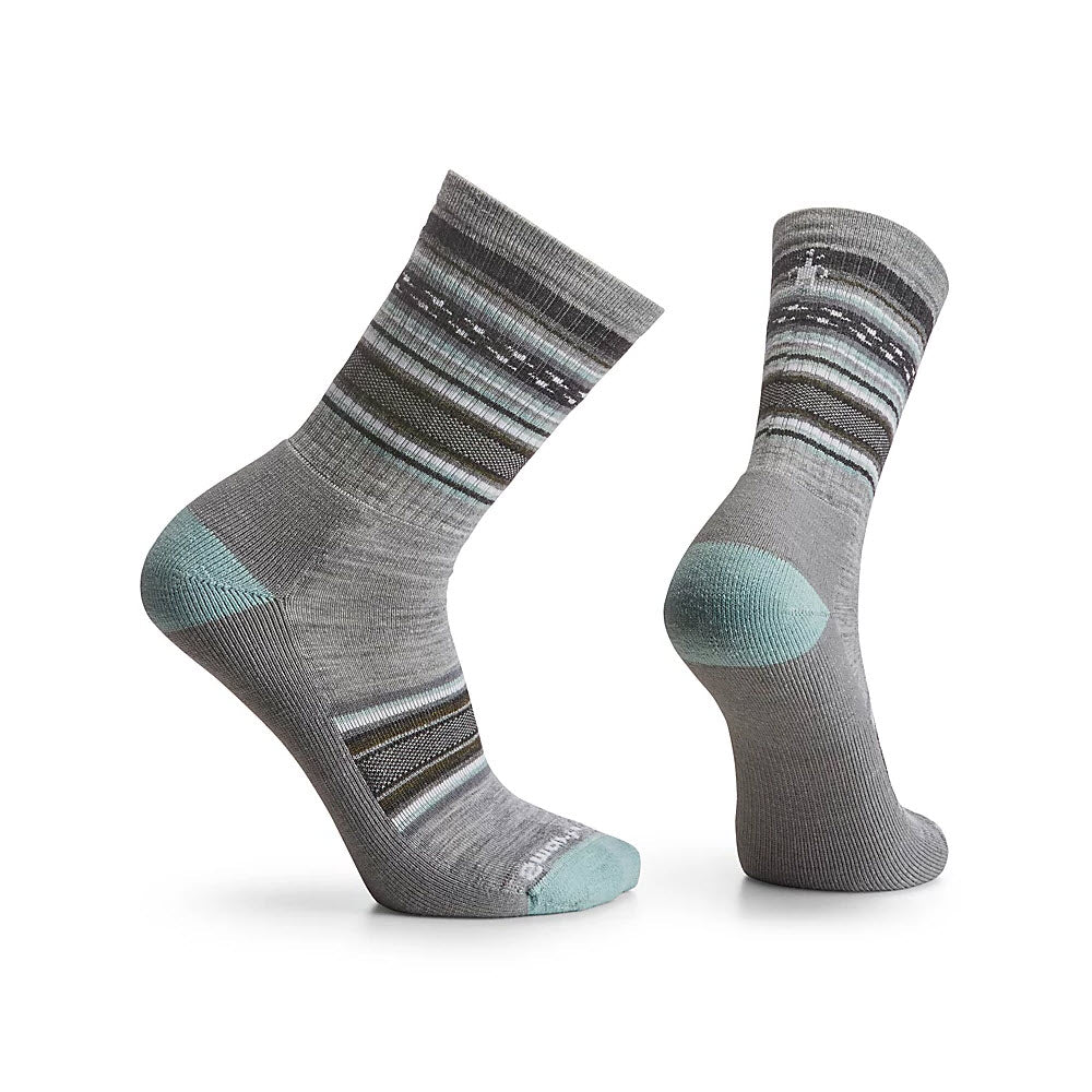 A pair of Smartwool REGARITA CREW SOCKS in light gray with teal accents and horizontal stripes, presented standing without feet, against a white background.