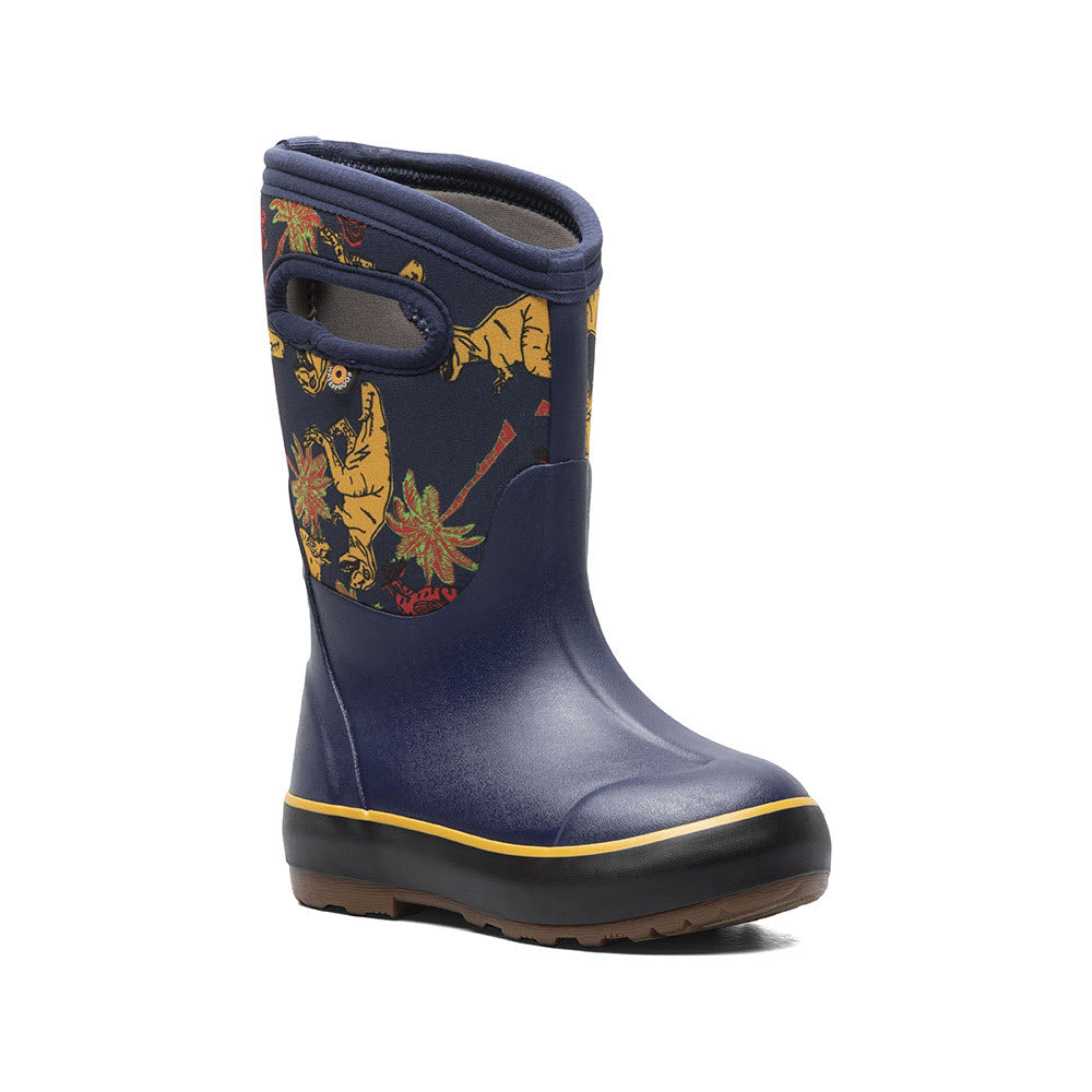 A Bogs navy blue children&#39;s rain boot with colorful autumn leaf patterns and yellow trim around the sole, designed for natural foot movement, isolated on a white background.