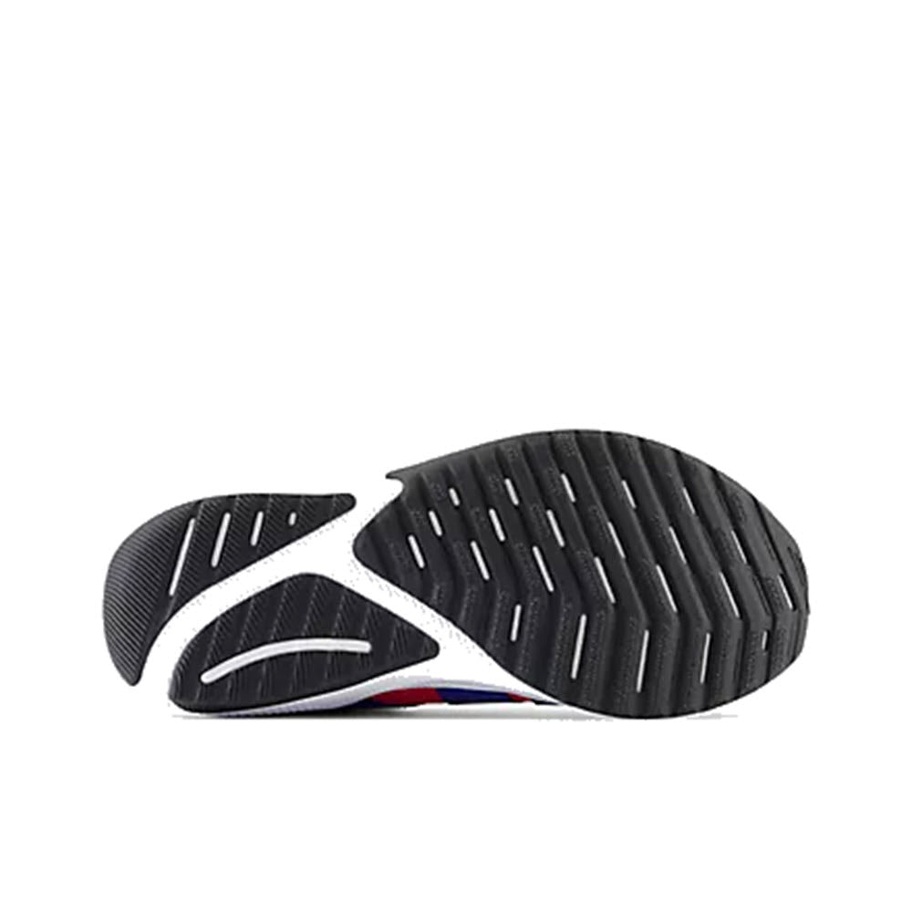 Sole of a New Balance Reveal V4 BOA True Red/Marine kids&#39; sneaker with a black and white tread pattern, featuring white cutouts and a red and blue accent under the arch.