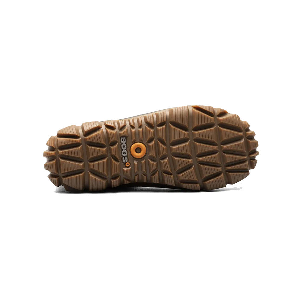 Bottom view of a rugged, slip-resistant Bogs shoe sole with deep treads and a central logo, isolated on a white background.