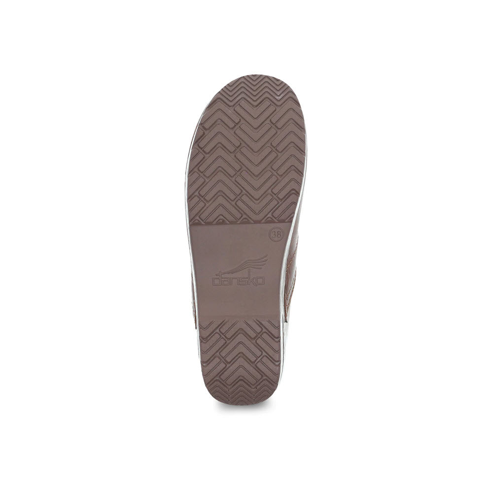 Bottom view of a DANSKO PROF SADDLE FULL GRAIN - WOMENS displaying its brown sole with a zigzag pattern and the logo &quot;Dansko Professional clog&quot;.