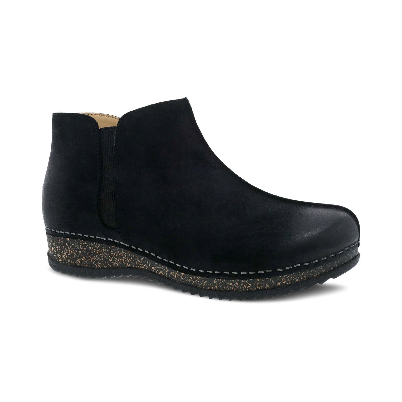 Dansko Makara bootie in black suede with a low wedge heel and speckled sole, isolated on a white background.