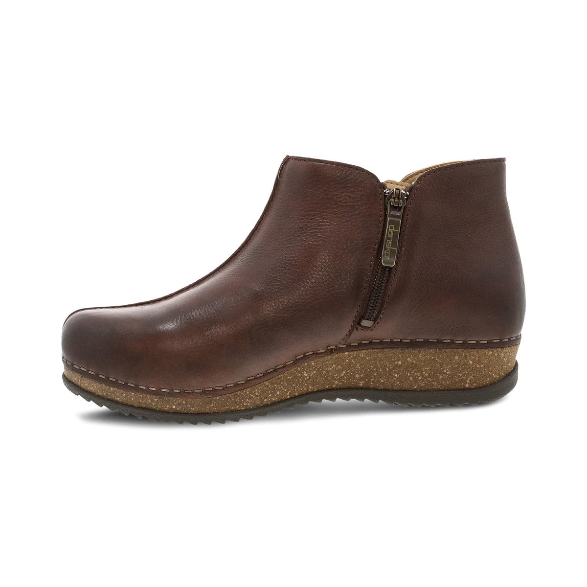 A single brown leather Dansko Makara bootie with a side zipper and a cork sole, isolated on a white background.