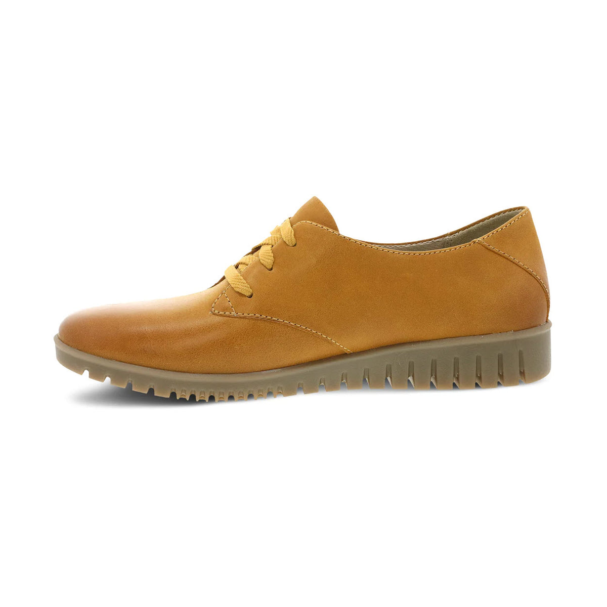 A single Dansko Libbie Mustard Burnished Oxford shoe with laces and a thick, ridged sole, displayed on a white background.