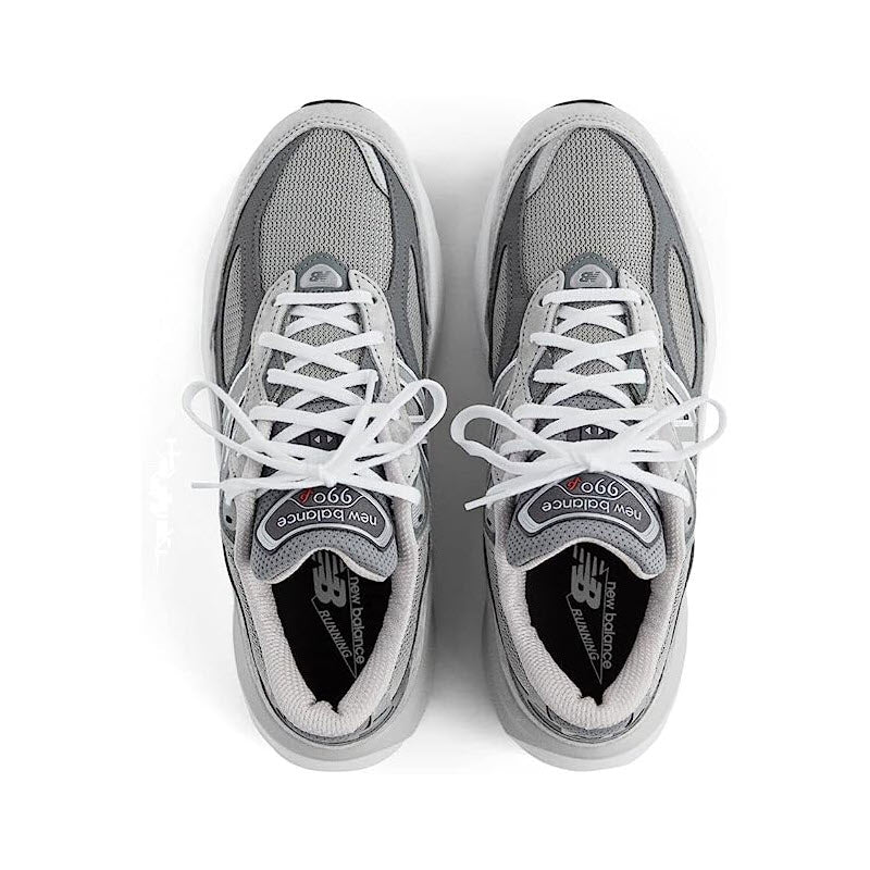 Top view of a new pair of grey New Balance 990 V6 running shoes with white laces, branded insoles visible, isolated on a white background.