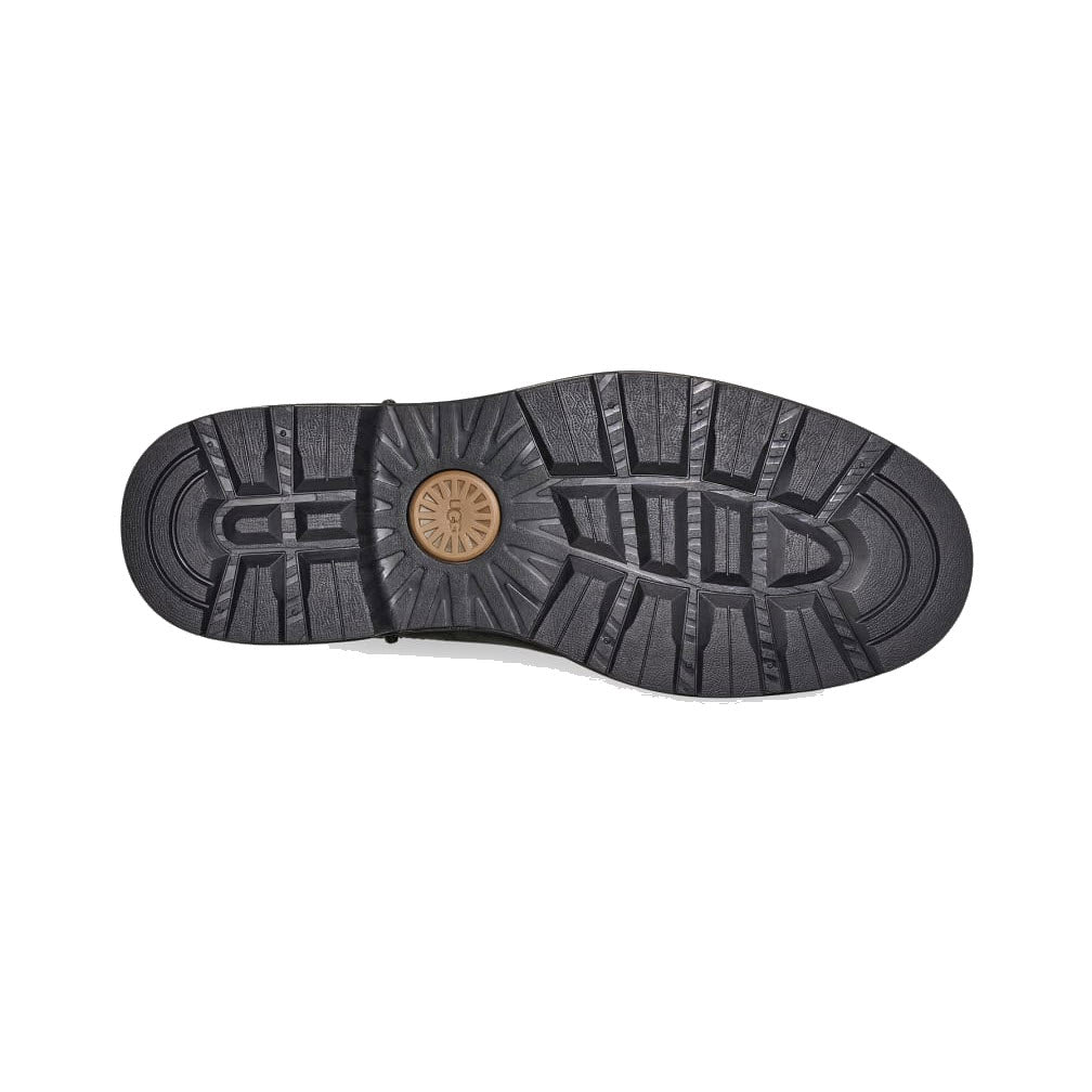 Bottom view of a UGG BILTMORE WATERPROOF CHELSEA BLACK - MENS sole showing tread pattern and a central circular Ugg logo.