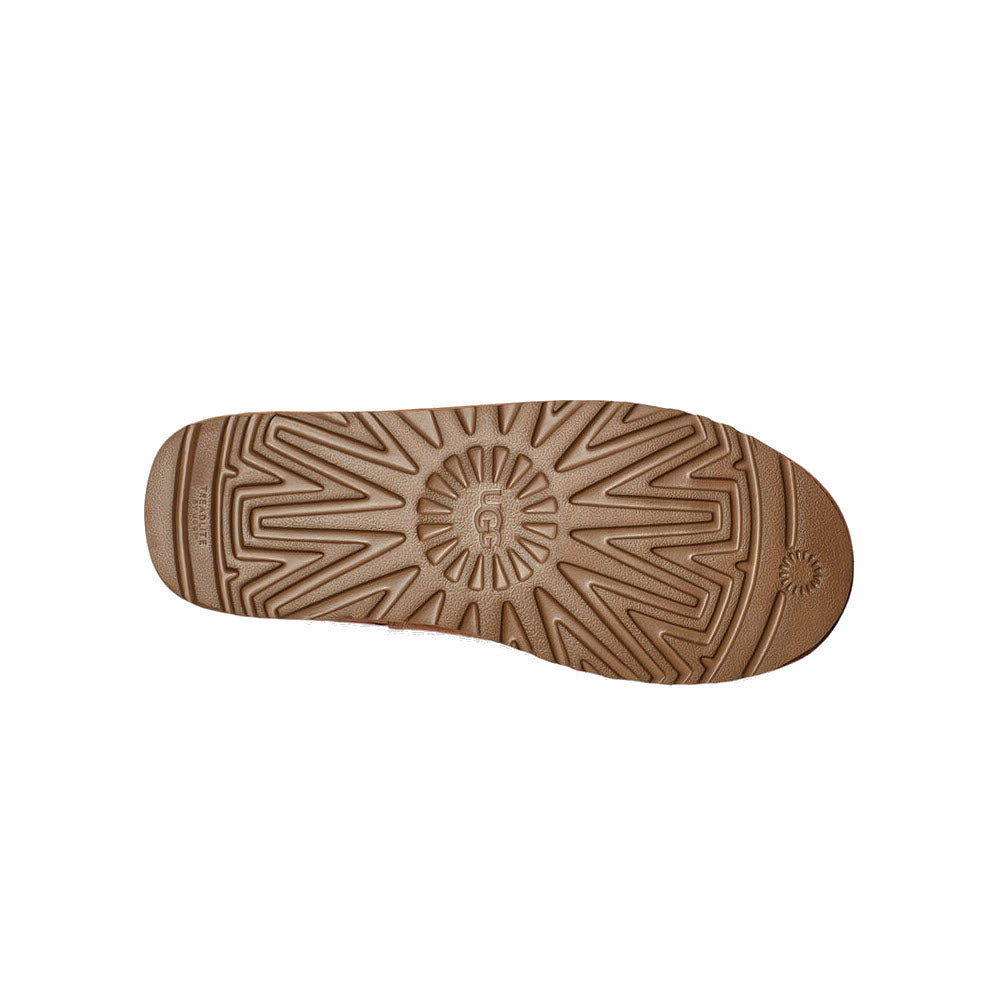 Sole of an Ugg shoe displaying a detailed pattern design with a central emblem, photographed on a white background, featuring lightweight foam cushioning.