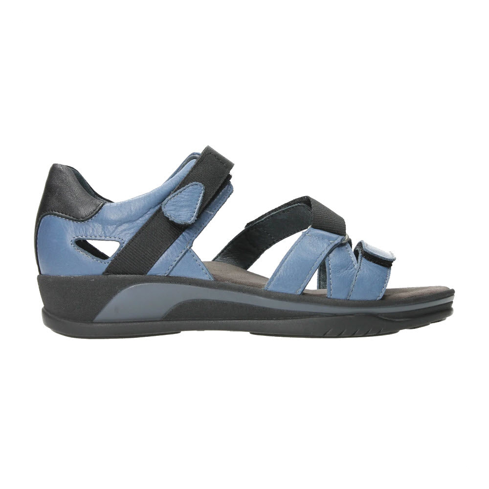 A side view of a Wolky Desh Jeans women's sandal with adjustable Velcro straps and a memory foam cushioned sole, isolated on a white background.