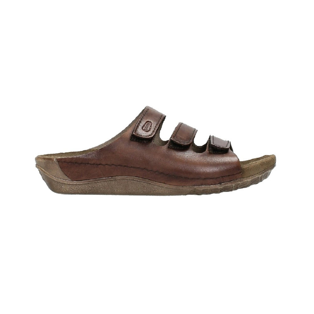 Side view of a cognac leather women's Wolky Nomad Slide Sandal with three adjustable straps and a thick sole, isolated on a white background.