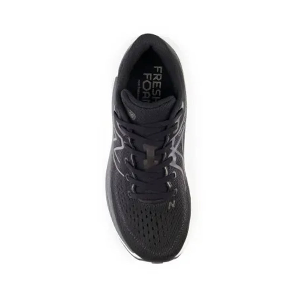 Top view of a single New Balance 860 V13 black running shoe with a white sole and laces, featuring &quot;Fresh Foam X&quot; text on the insole.