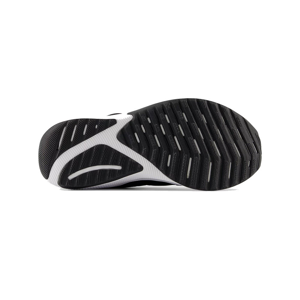 Sole of a kids&#39; New Balance Reveal v4 sneaker with black and gray tread pattern, viewed from below.