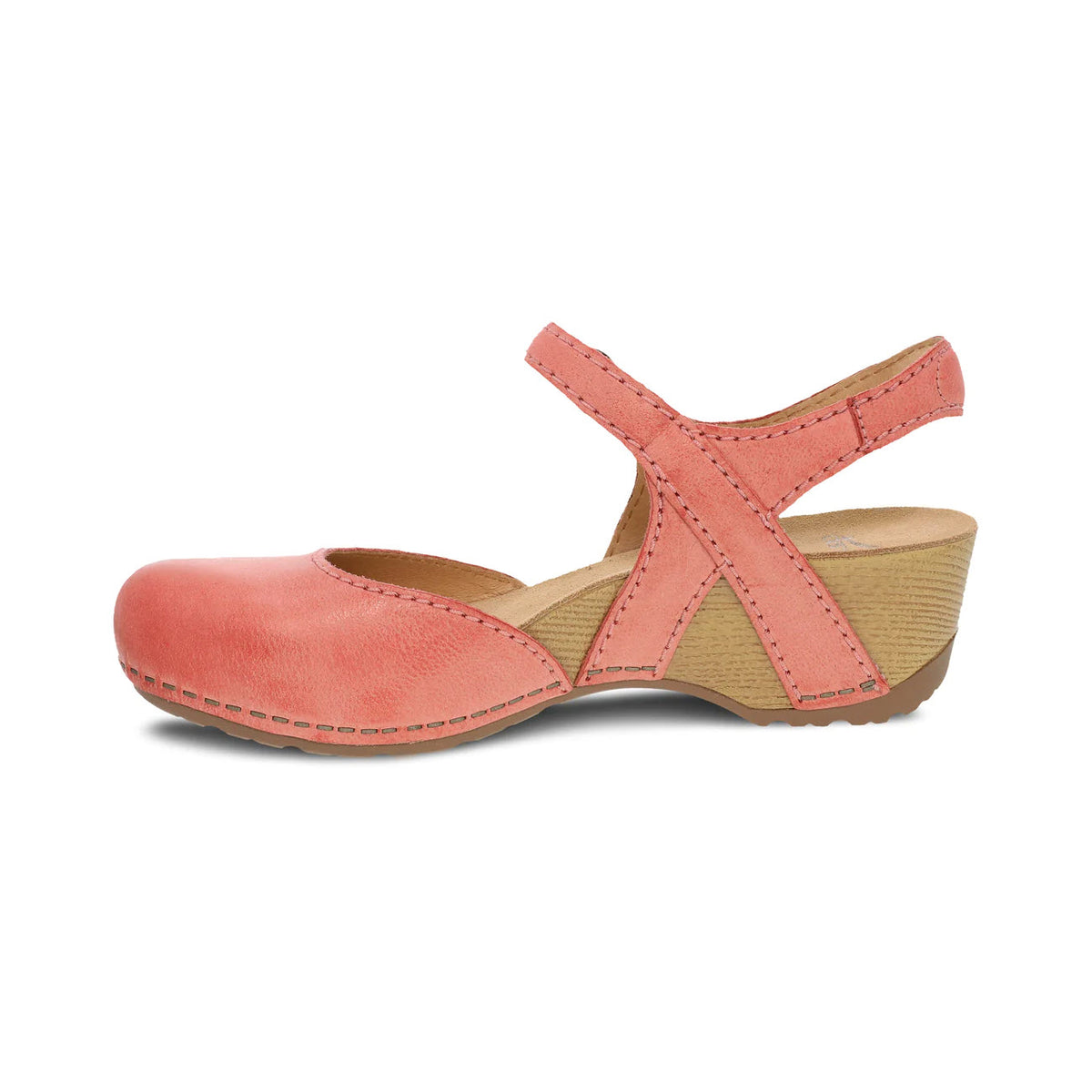 A single Dansko coral-colored leather mary jane shoe with a strap over the instep and a low wooden heel, wear-anywhere style, isolated on a white background.