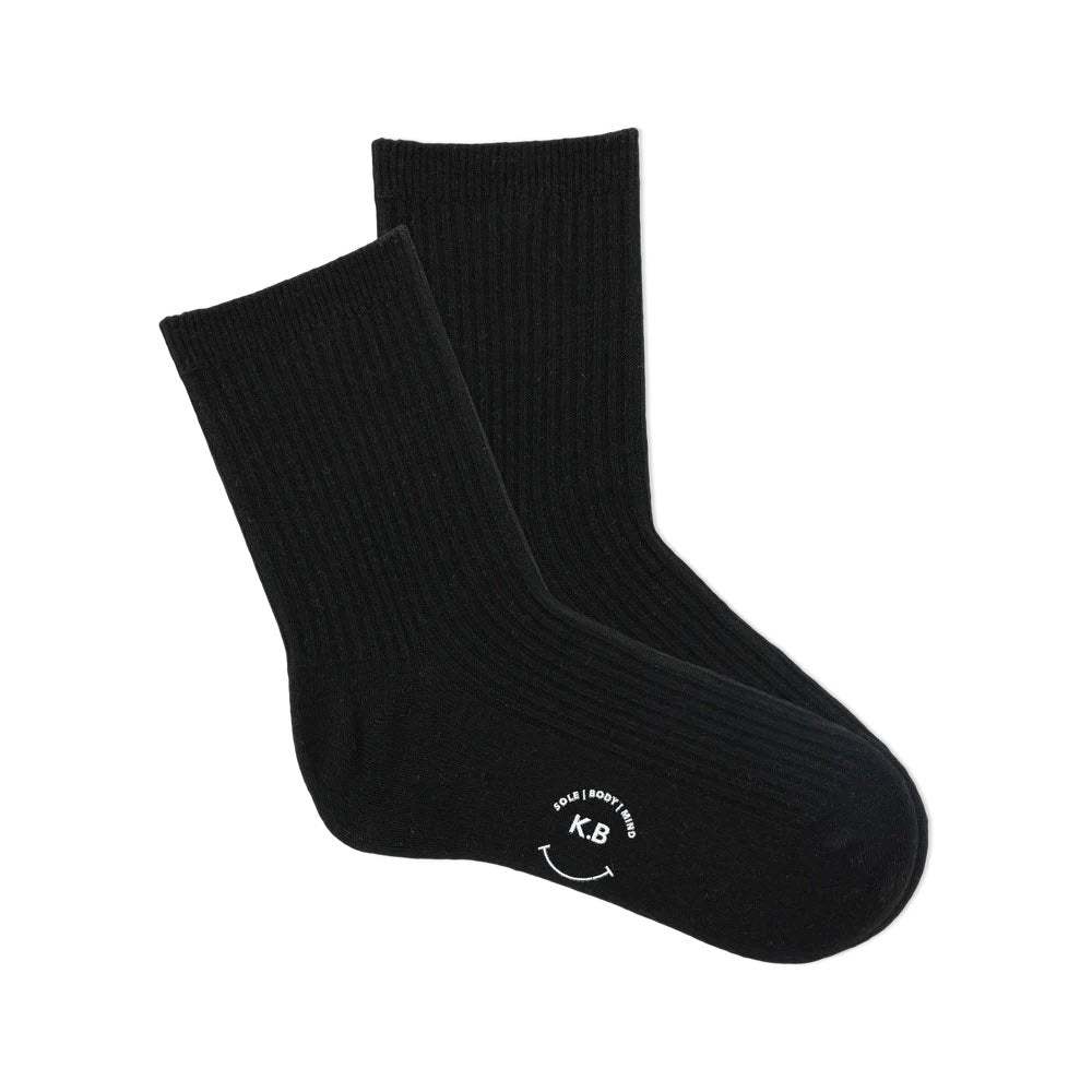 A pair of K. Bell black ribbed ankle crew socks with a white logo on the sole, displayed against a white background.
