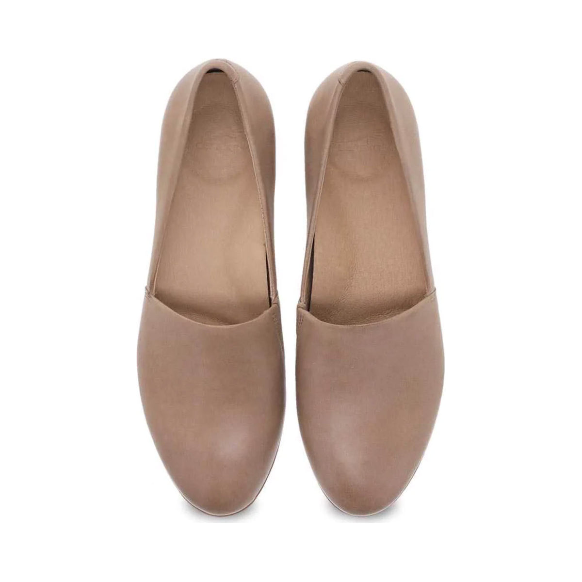 A pair of beige Dansko Larisa Taupe slip-on flat shoes isolated on a white background.