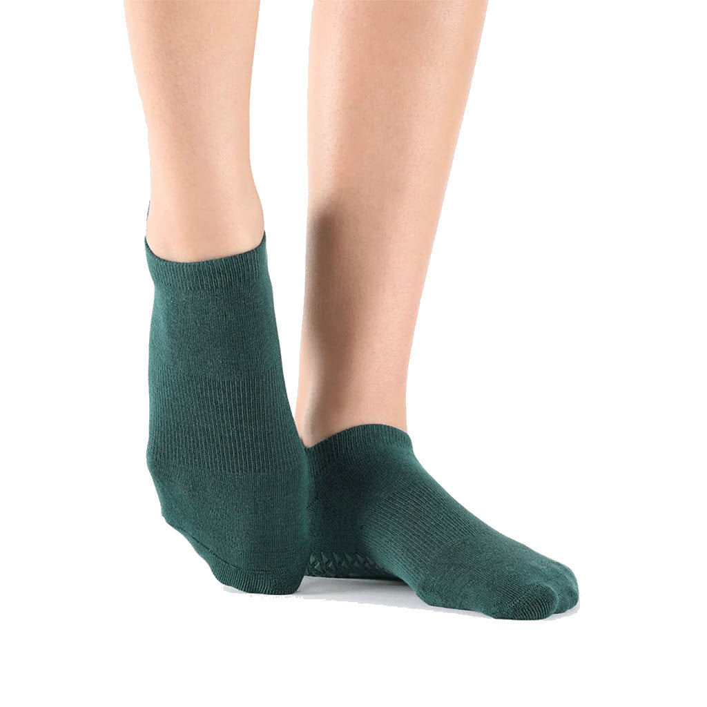 A person standing in POINTESTUDIO POINTE STUDIO UNION LOW GRIP SOCKS SAGE against a white background.