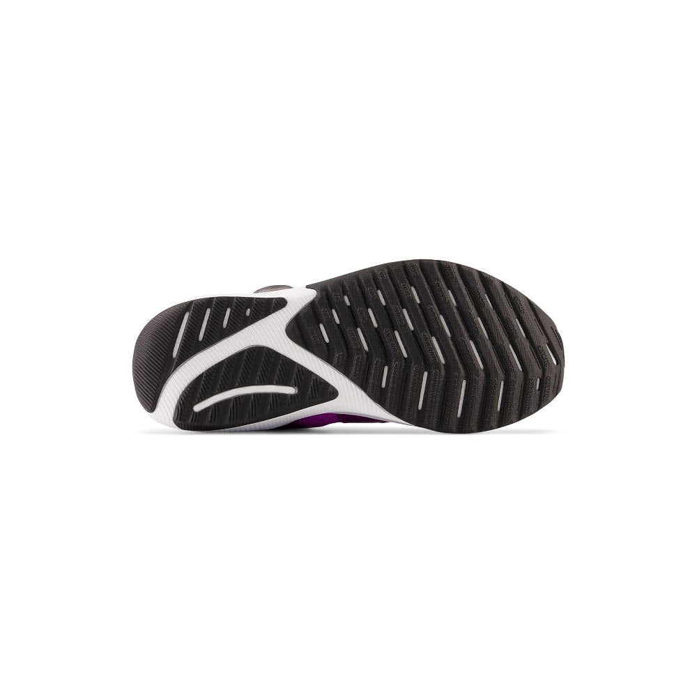 Bottom view of a New Balance Reveal Boa V4 Cosmic Rose - Kids running shoe showing its black and white tread pattern with a small purple accent.