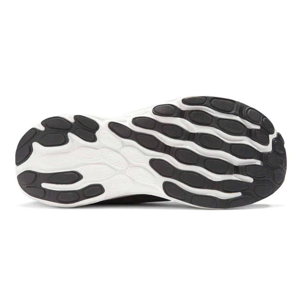 Bottom view of a NEW BALANCE 1080K13 BLACK - WOMENS shoe with a white and black rubber sole featuring an organic, pod-like tread pattern and enhanced cushioning.