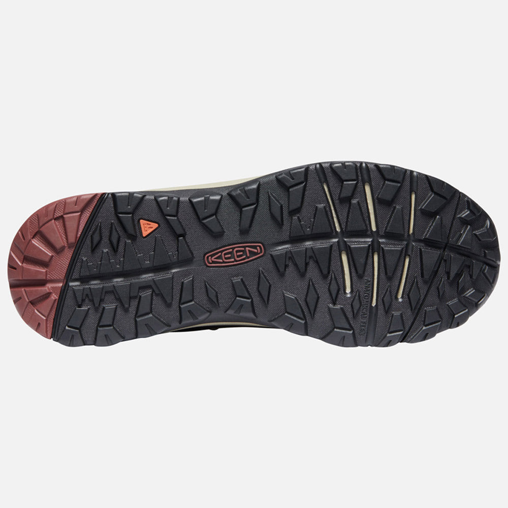 Durable Keen TERRADORA II MID CANTEEN/ANDORRA rubber outsole of a hiking shoe with a tread pattern, featuring the keen logo and dual-tone sections in black and red.