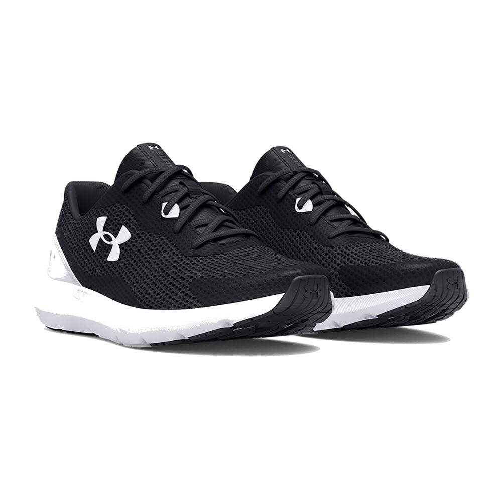 A pair of black Under Armour Surge 3 shoes with cushioned white soles, displayed against a white background.