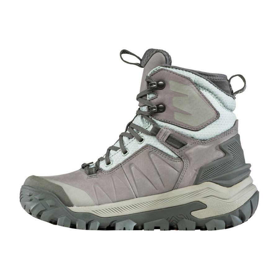 A single Oboz Bangtail Mid Insulated BDRY Winter Quartz women&#39;s hiking boot with rugged tread and lace-up front, featuring gray and white accents and high ankle support.