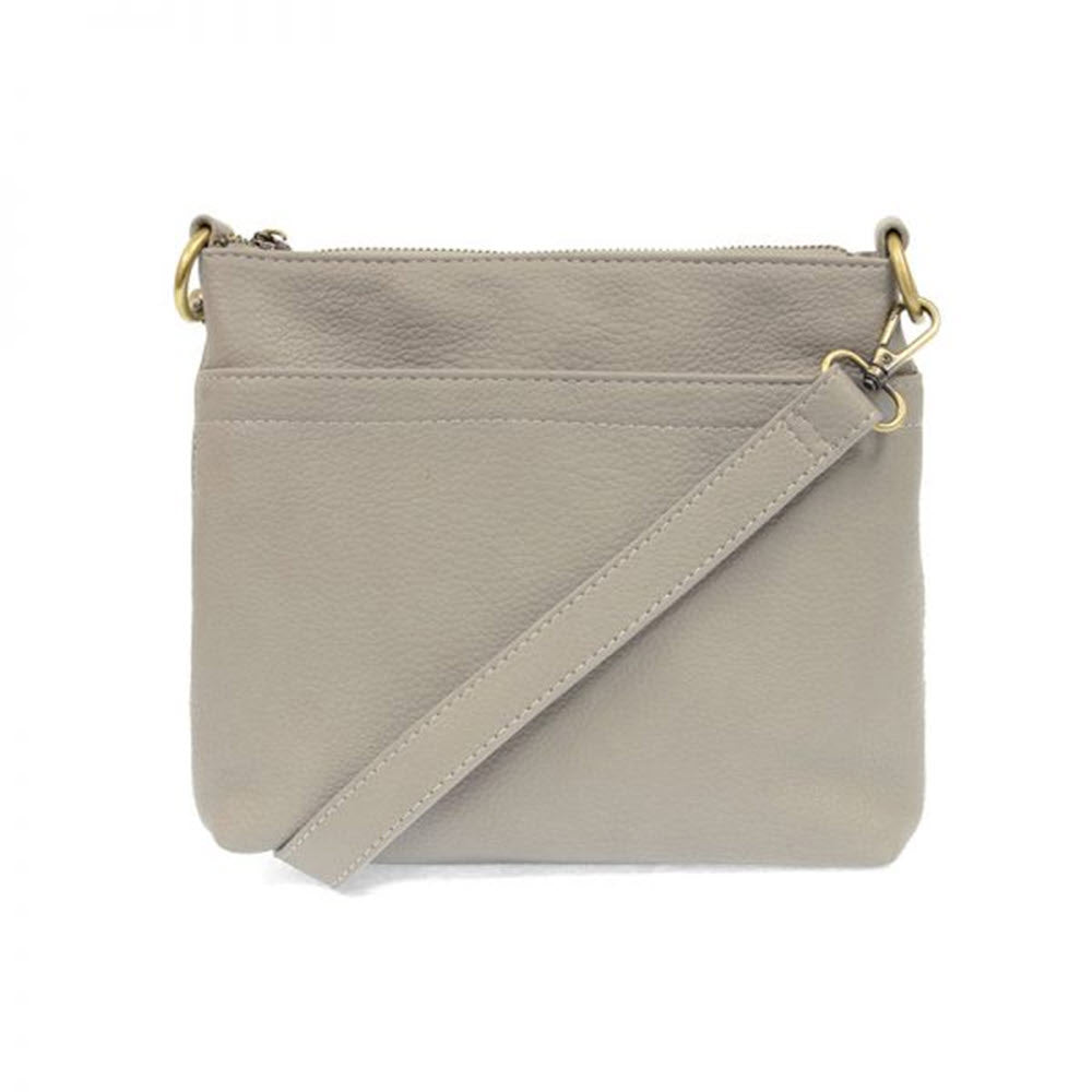 Beige Joy Susan Layla double-zipper crossbody bag with a front zipper, exterior pockets, and a detachable strap.