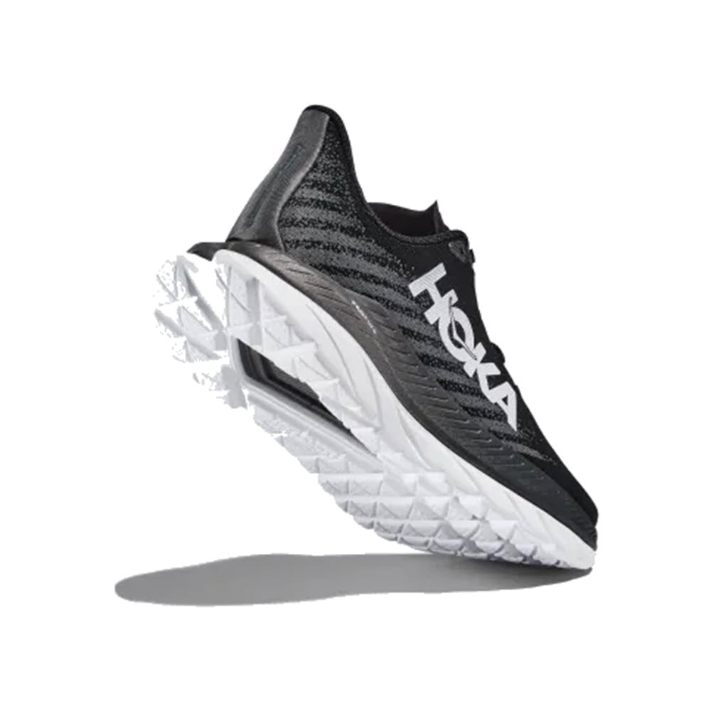 A single black and white HOKA MACH 5 running shoe suspended in mid-air against a plain white background.