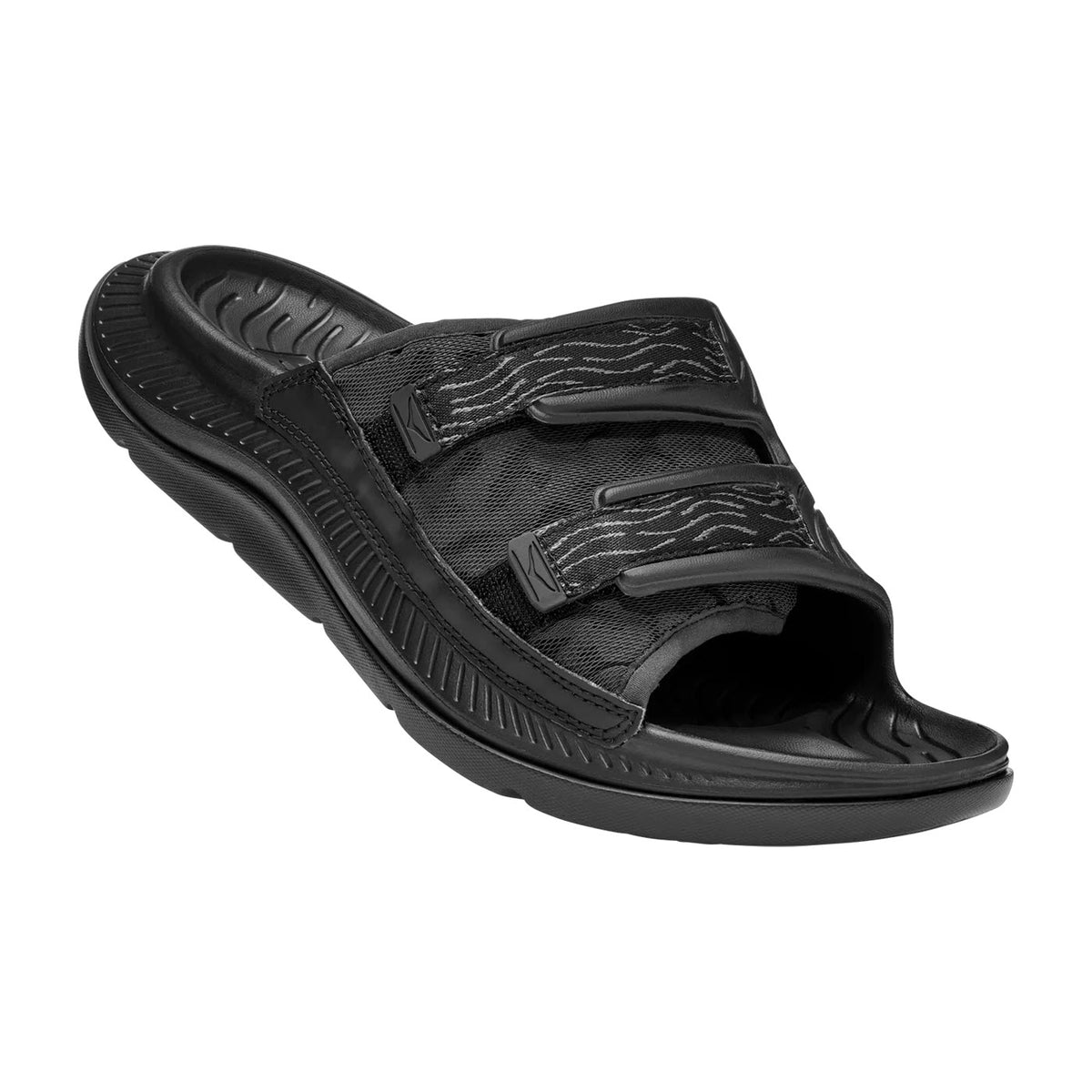 A single black ORA LUXE BLACK/BLACK - ADULT recovery slide with an adjustable Ariaprene® strap and a molded footbed, isolated on a white background by Hoka.