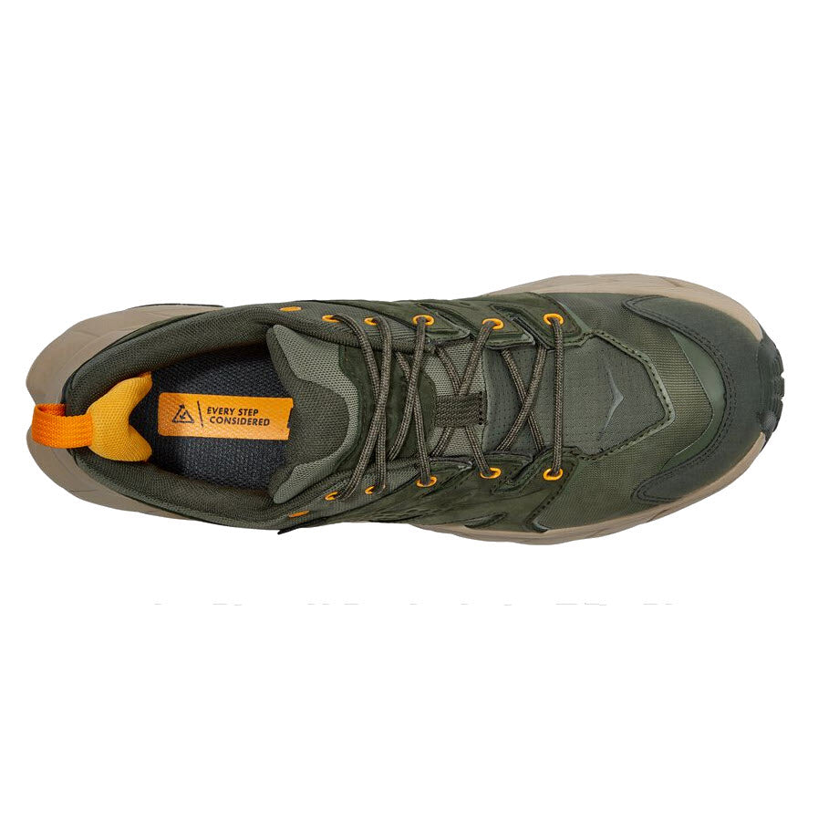 Top view of the Hoka Anacapa Low GTX hiking shoe in olive green with orange detailing and a grey sole, featuring reinforced toe protection.