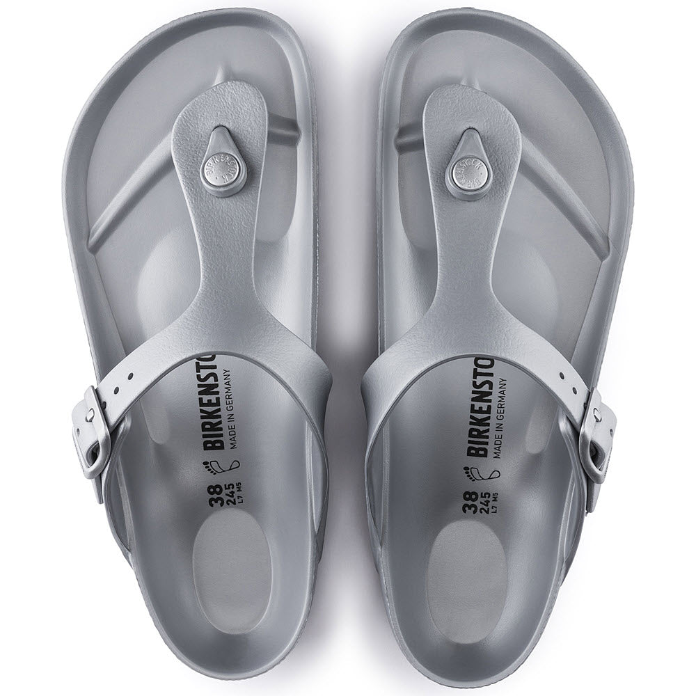 A pair of gray Birkenstock Gizeh EVA Metallic Silver thong sandals viewed from above, showcasing the brand name on the insole and adjustable straps.