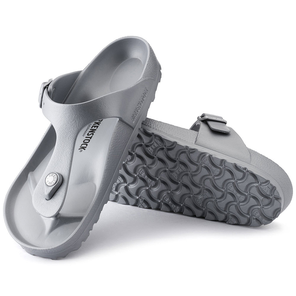 A pair of silver Birkenstock Gizeh EVA Metallic Silver thong sandals with adjustable buckles and textured soles, positioned against a white background.