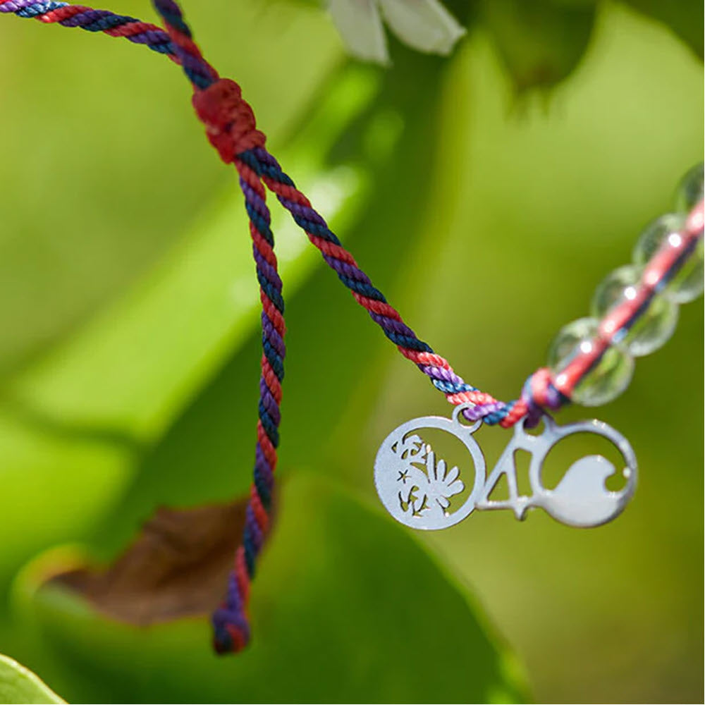 4Ocean bracelet Mesoamerica with pendants crafted from ocean trash, outdoor shot with greenery in the background.