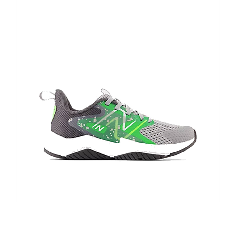 A gray athletic sneaker with green accents, white laces, and a white sole. The shoe features a speckled design near the middle, with a white N logo on the side and a pull tab at the heel.
