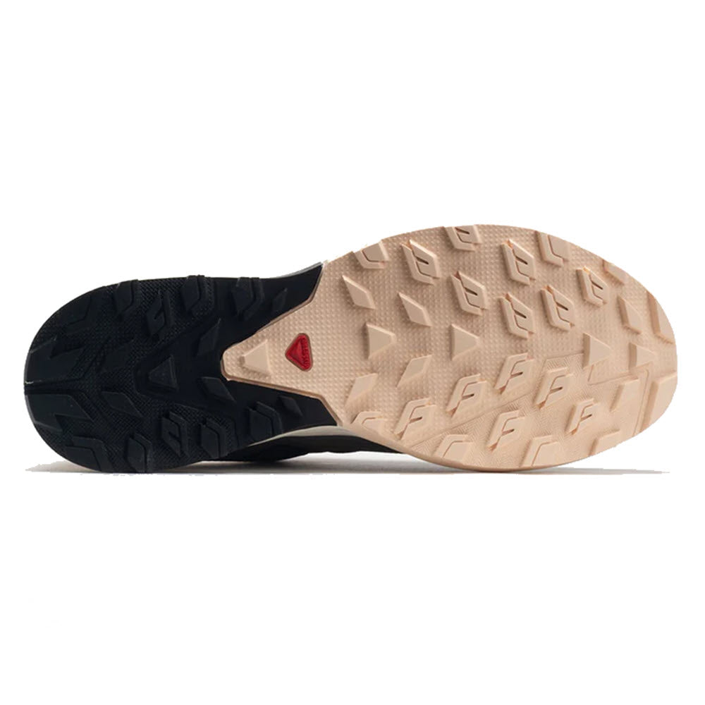 Bottom view of a Salomon Outrise CSWP Magnet - Women hiking shoe with a dual-tone sole featuring a distinctive triangular tread pattern and a small red heart detail.