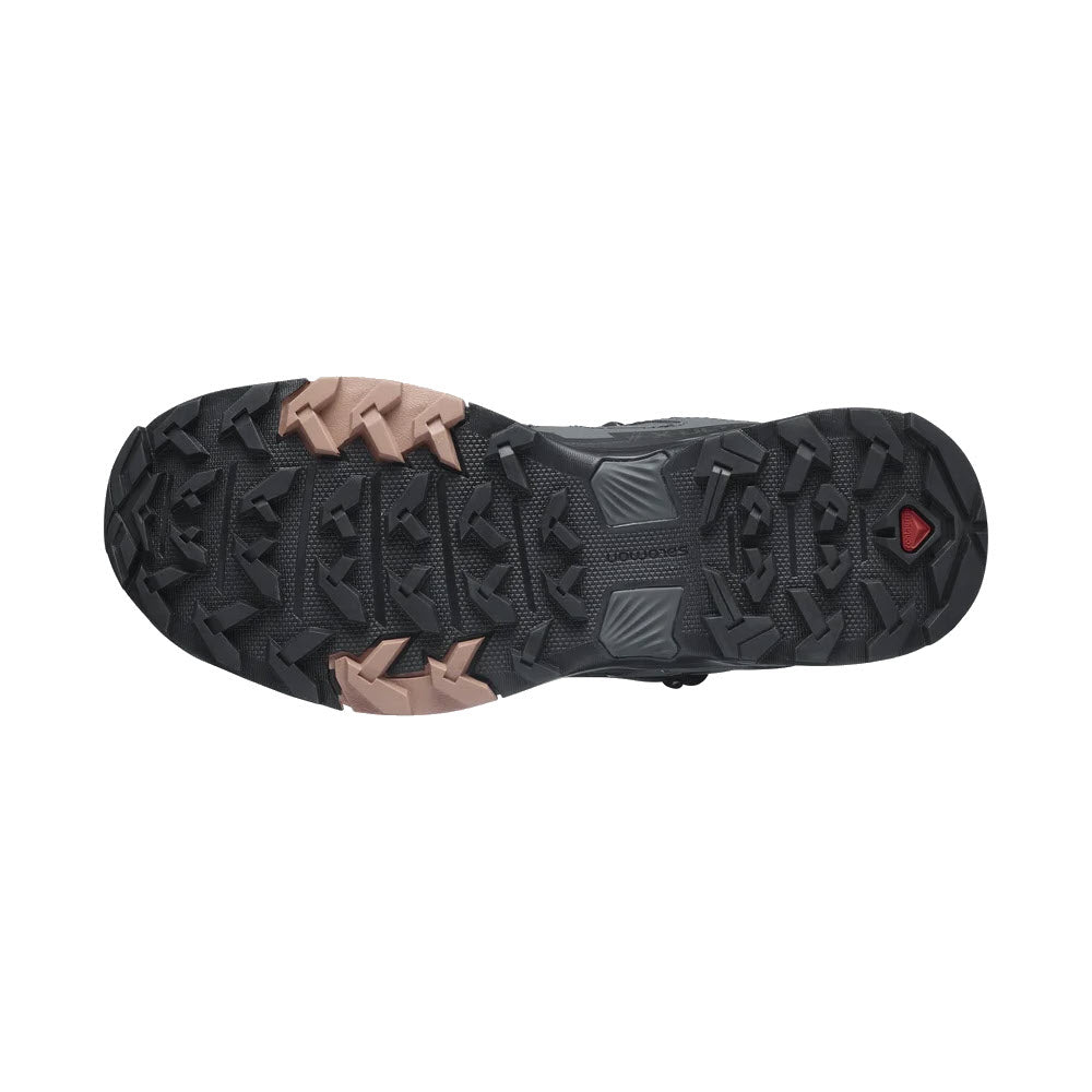 Bottom view of a Salomon X Ultra 4 Mid GTX Ebony/Mocha Mousse/Almond Cream - Womens hiking boot featuring a detailed tread pattern with black and brown grippy outsole grips and a red logo.