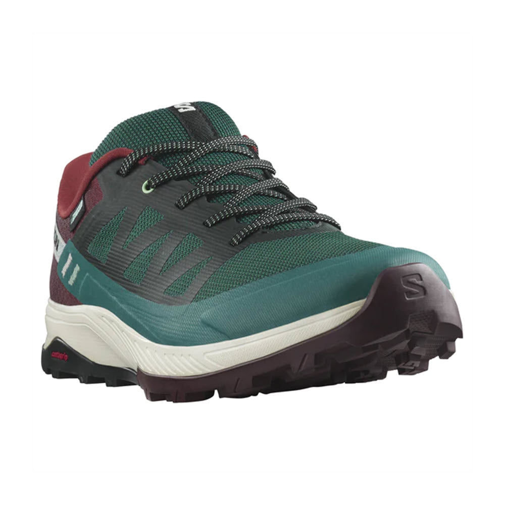 Green and gray Salomon OUTRISE CSWP trail running shoe with red accents and visible branding, featuring a sturdy sole design for grip.