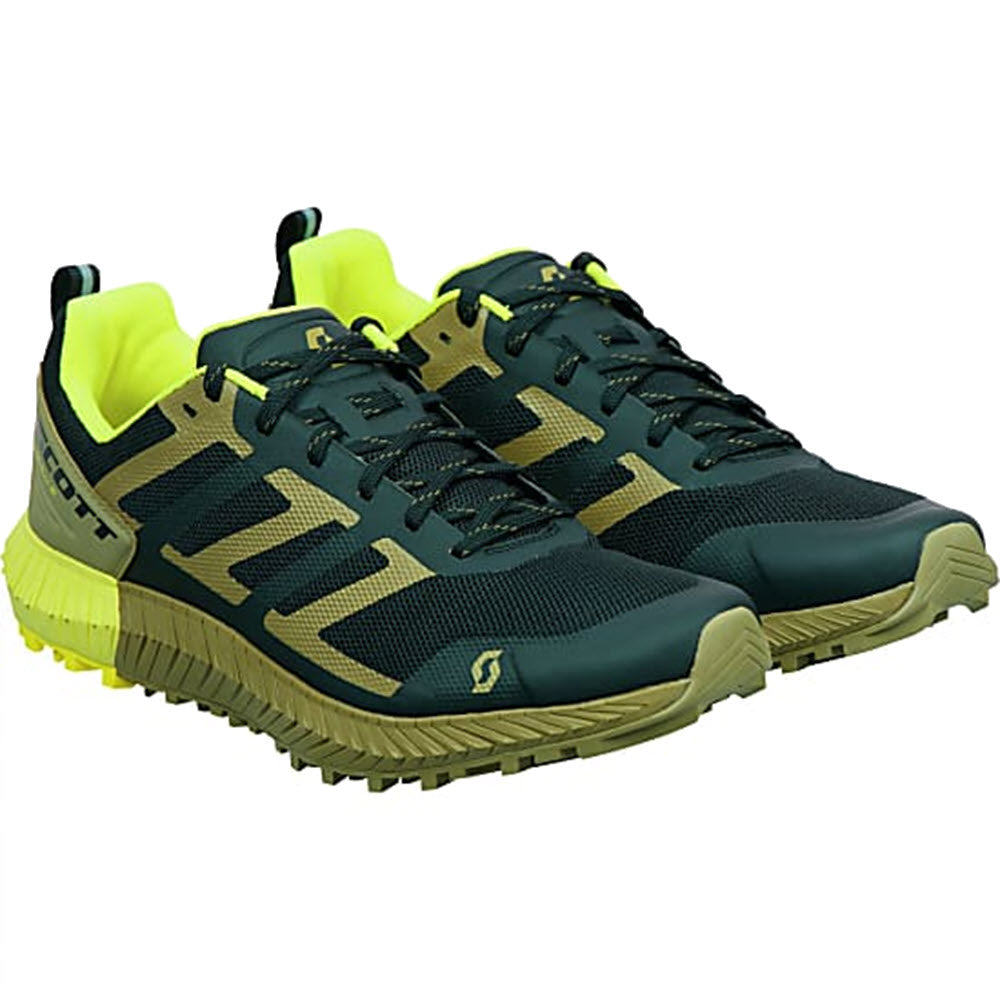 A pair of Misc SCOTT KINABALU MUD GREEN/YELLOW - MENS trail running shoes with dark navy uppers and vibrant yellow accents, featuring a robust tread on the soles for trail running.