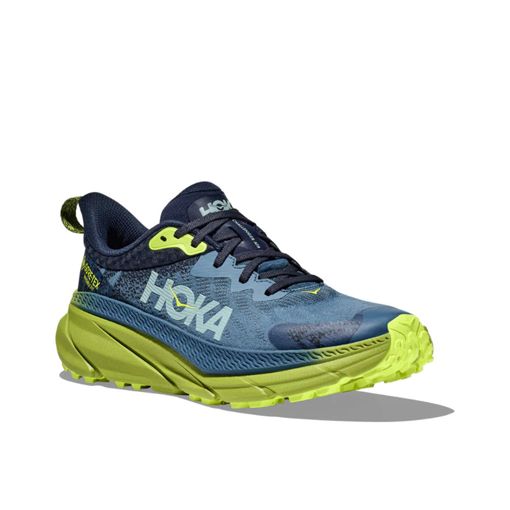A blue and lime green Hoka Challenger ATR 7 GTX trail running shoe with improved traction and branding on the side.