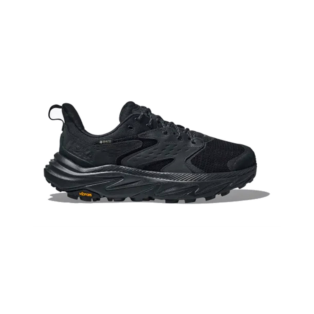 A black Hoka GORE-TEX waterproof trail running shoe with prominent ridged soles and visible Vibram logo on the side.