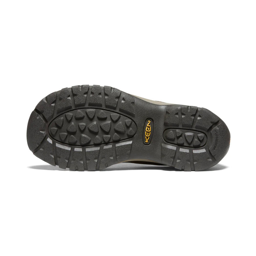 The image shows the black rubber sole of a KEEN KACI III WINTER DARK EARTH - WOMENS shoe with multiple treads and deep grooves designed for traction, ensuring both warmth and waterproofing.