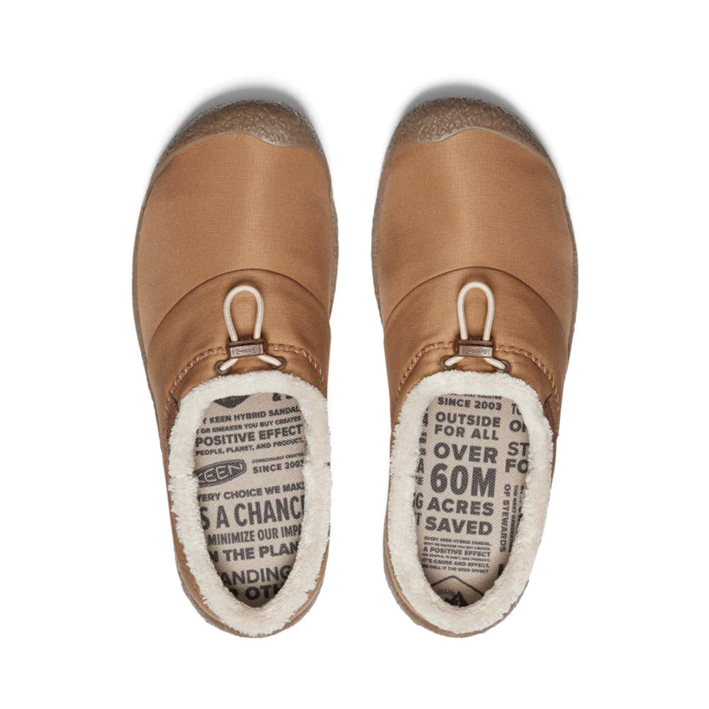 KEEN HOWSER III TOASTED COCONUT - WOMENS by Keen, slip-on shoes with a woolly lining, offering a cozy fit. The insoles feature text promoting sustainability and environmental benefits, making these hybrid comfort slides the perfect blend of style and conscience.