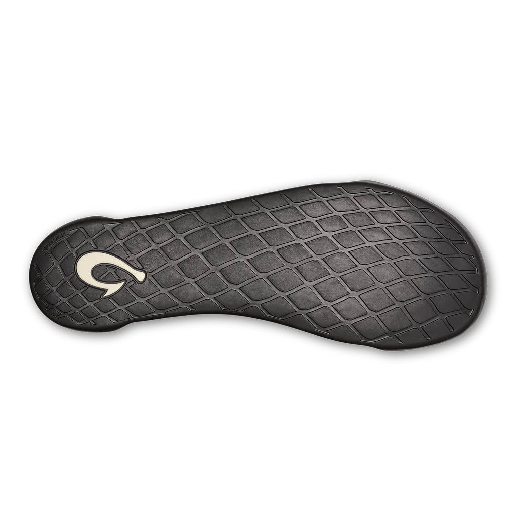 Sole of an Olukai Hanohano Canvas Shearling Slipper Dark Shadow - Mens with a black diamond pattern and a logo resembling a stylized letter &quot;g&quot; near the central area, composed of genuine shearling, on a white background.
