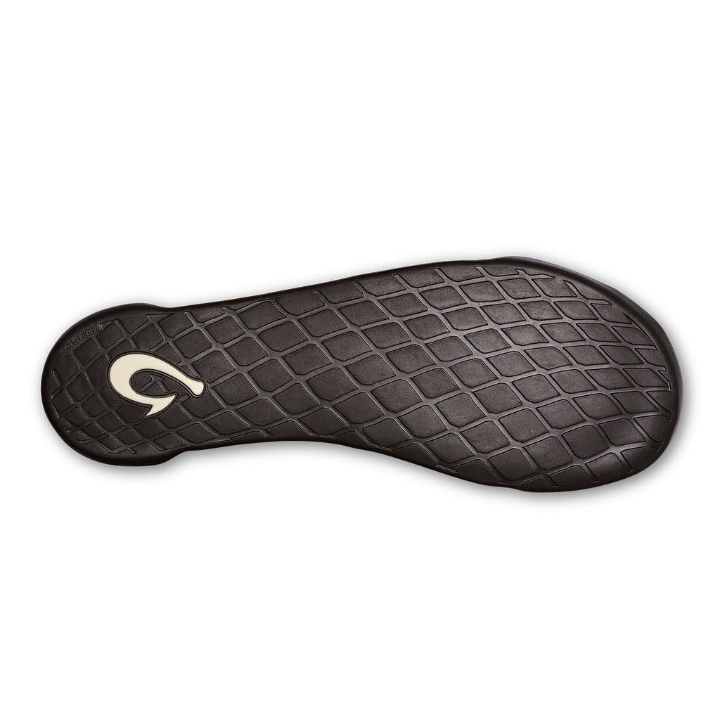Sole of an Olukai black sports shoe featuring a diamond tread pattern and a logo resembling a stylized letter &quot;q&quot; in an island-inspired style circle.